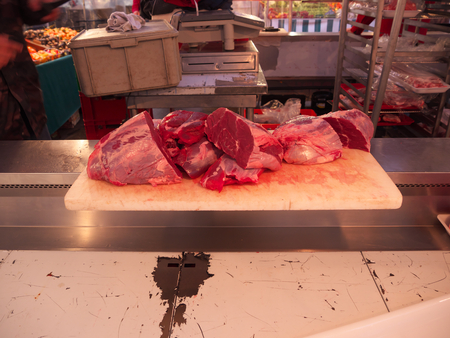 Meats sold at Street market in Paris. People walking and buying foodの写真素材