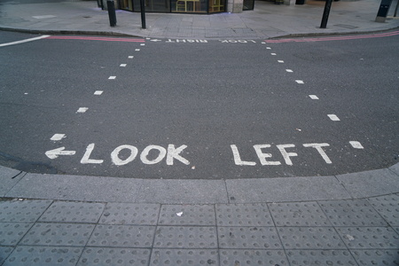 text look left in white letters on asphalt of street in Londonの写真素材
