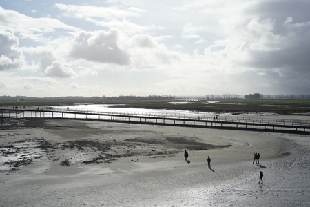 The Normandie, France-January 26, 2018: People walk on the bridge and the sand beach near Mont-Saint-micel at low tide.のeditorial素材