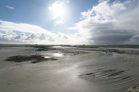 The Normandie, France-January 26, 2018: People walk on the bridge and the sand beach near Mont-Saint-micel at low tide.のeditorial素材