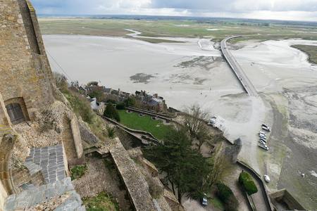 The Normandie, France-January 26, 2018: People walk on the bridge and the sand beach near Mont-Saint-Michel at low tide.のeditorial素材