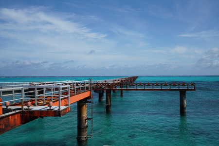 A small pier for boats to dock on a blue waterの写真素材
