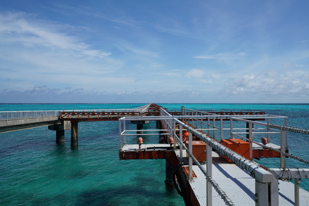 A small pier for boats to dock on a blue waterの写真素材