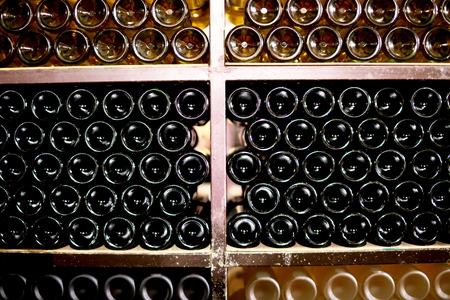 Wine bottles in a dark wine cellarの写真素材