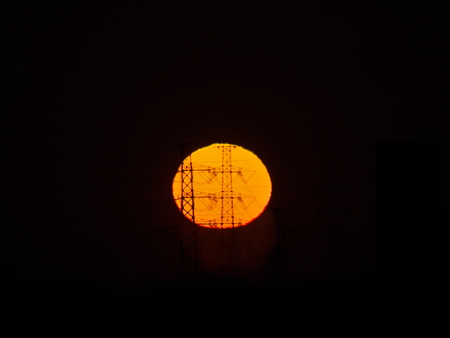 Tokyo, Japan-February 12, 2019: The rising sun beyond transmission towers in Tokyoの写真素材