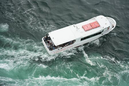 Naruto, Japan-September 28, 2019: The world largest whirlpools in Naruto Channel and a sightseeing boatのeditorial素材
