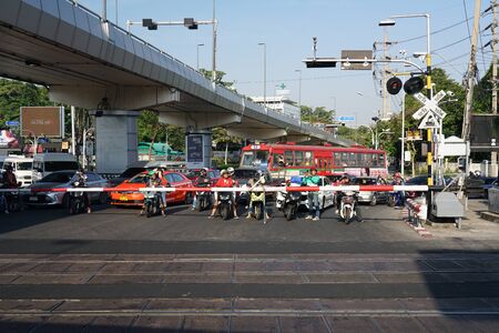 Bangkok,Thailand-December 5, 2019: People waiting for a steam locomotive train to pass at a railroad crossing of Phetchabu ri road and Phiisanulok Road in Bangkok.のeditorial素材