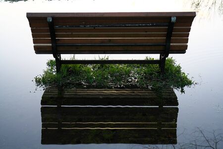 Tokyo, Japan-April 15, 2020: Benches in a puddle after the heavy rain in the morning in Tokyo, Japanの写真素材