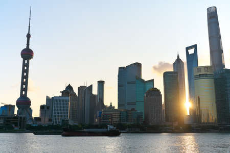 Shanghai,China-September 16, 2019: The sun rises between Pudong New Area buildings in Shanghaiのeditorial素材