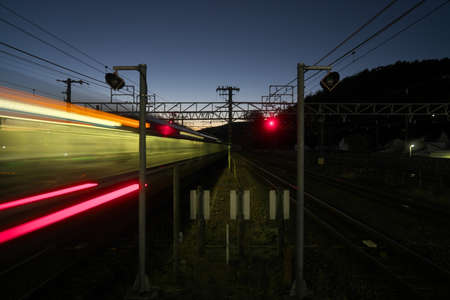 Kyoto,Japan-November 21, 2020: A train passing a station at dusk in Kyotoの写真素材