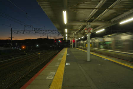 Kyoto,Japan-November 21, 2020: A train passing JR Yamashina station at dusk in Kyotoの写真素材