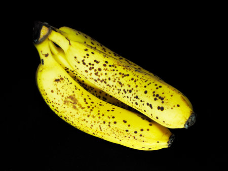 Banana with black spot isolated on blackの写真素材