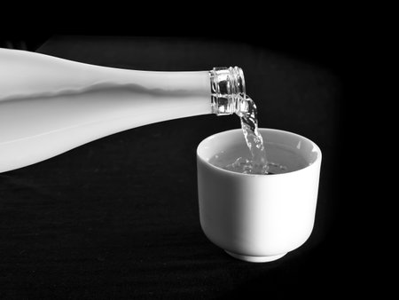 Pouring Sake into a small sake cup or Chokoの写真素材