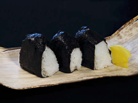 Tokyo,Japan - October 9, 2021: Rice balls or Onigiri on bamboo skin on black background