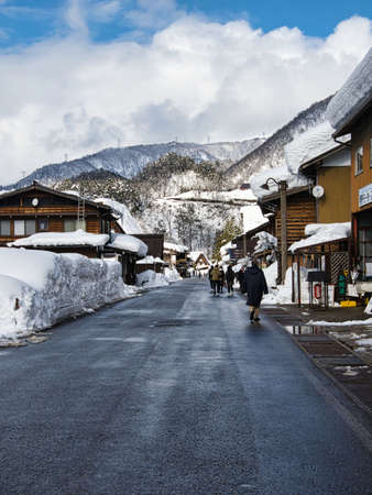 Shirakawago, Japan - February 18, 2022 : A snow-covered street in Shirakawago village in winter,...