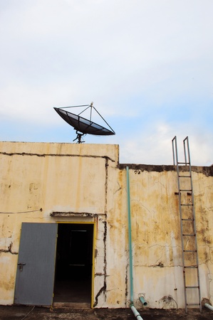 Satellite dish on office building and old door and floorの写真素材