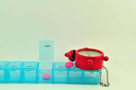 Pill box and red clock show medicine timeの写真素材
