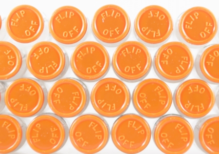 Top view of orange cap injection in tray show medicine background