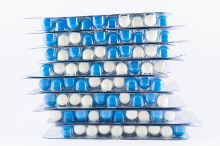 Closed up layer of blue and white capsule in blister pack on white