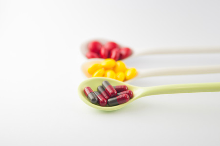 Spoon with tablet and capsule show medicine concept