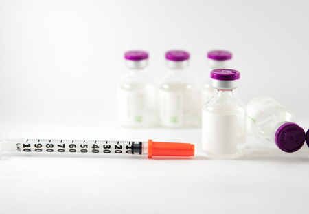 Purple cap injection vials and syringe show medicine concept