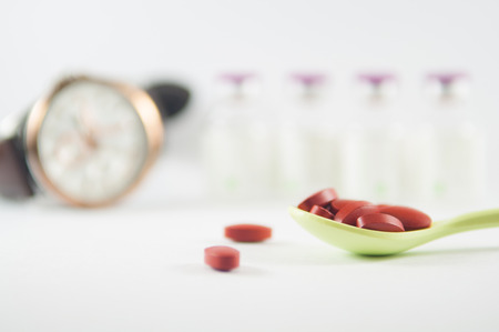 Brown tablet in spoon on medicine background