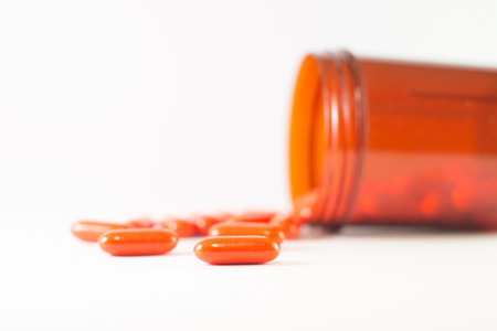 Orange tablet and medicine brown bottle show pharmaceutical conceptの写真素材