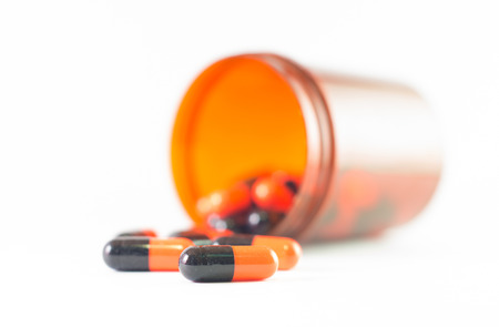 Orange black capsule and brown medicine bottle