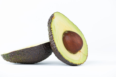 Cross section of avocado fruit on white