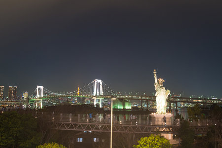 Odaiba, Japan - Jan 28 2016: Liberty statue at Odaiba with rainbow bridge in background Tokyo, Japan.のeditorial素材