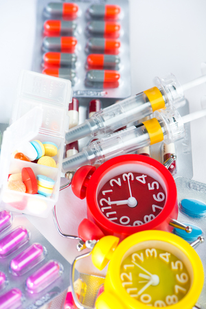 Alarm clock on medical blister pack show medicine time conceptの写真素材