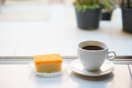 A cup of coffee and golden threads cakeの写真素材