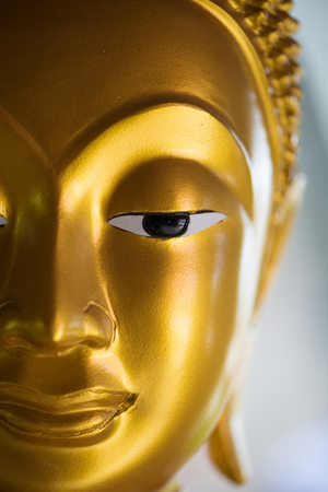 Closed up face of gold buddha in templeの写真素材