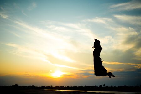Silhouette picture of girl jumping on beach