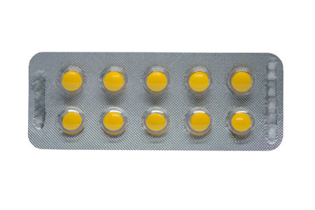 Yellow tablet in blister pack on white backgroundの写真素材