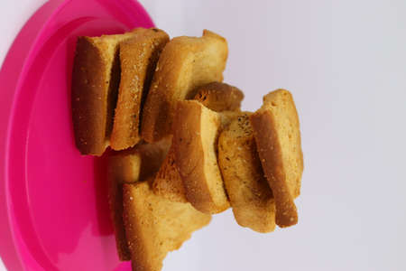 stack of dry toast on Plastics plate. Close Up Pile of toasted bread slices. Toast loaf on white...