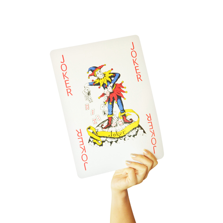 hand holding big joker card isolated on white backgroundの写真素材
