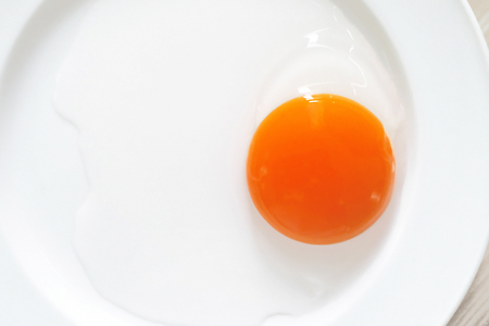 raw egg yolk on the dishの写真素材