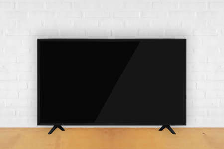smart tv on wooden table with white brick wall background