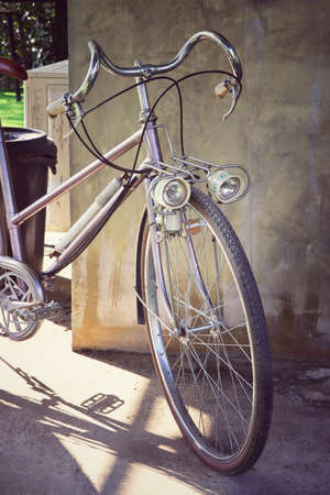 front view of vintage bicycle beside old cement wallの写真素材