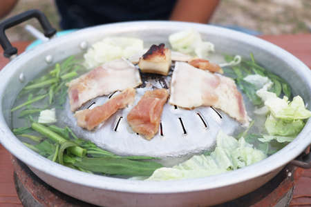Thai barbecue Grill Pork on hot pan, Thai style BBQ and vegetables soup, Moo Kra Ta