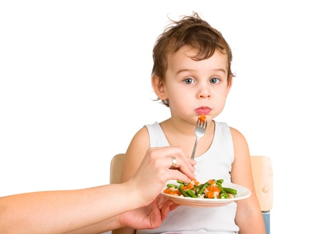 Little boy tasting vegetable saladの写真素材