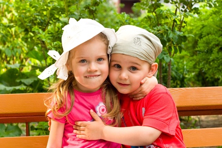 little boy and girl embrace in summer park の写真素材