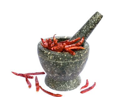 stone mortar with red chillies and garlic on white background