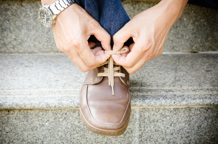 a Man lacing his suede shoesの写真素材