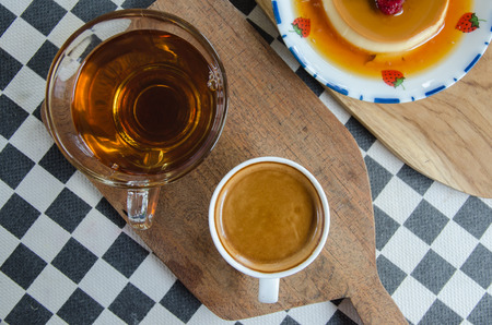 Espresso coffee in a white cup with caramel custard  on the table.の写真素材