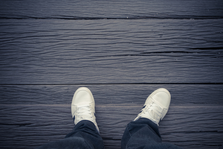 Foot and legs seen from above. Selfie.Foots over wood floor.