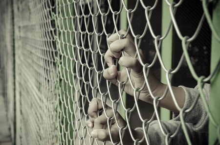 Hands with Mesh cage, Hands with steel mesh fenceの写真素材