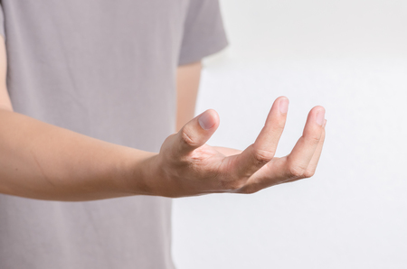 Young man offer hand and holding nothing. hands as if holding someting isolated on whiteの写真素材