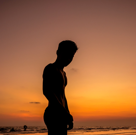Man silhouette stand alone on the beachの写真素材